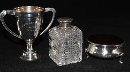 An Edwardian silver and tortoiseshell trinket box, a silver top bottle and a small silver trophy cup.